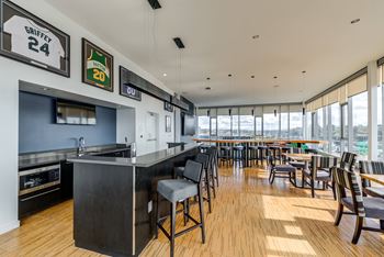 A modern bar with a wooden floor and a large window.